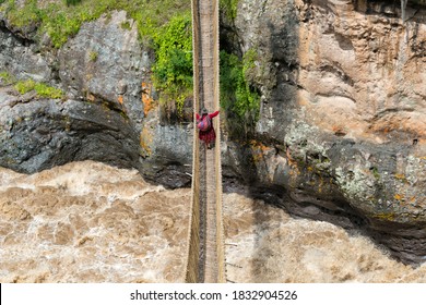 Quechua Woman Crossing Queshuachaca (Q'eswachaka) Rope Bridge, One Of The Last Standing Incan Handwoven Bridges, Quehue, Canas Province, Peru