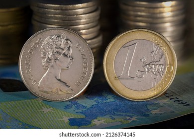 Queen Elizabeth And Euro Coins Standing On Europe Map Printed On 20 Euro Bank Note