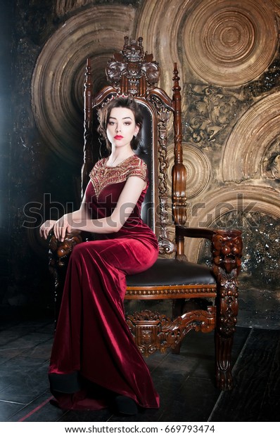 王座に座る赤いドレスを着た女王 パワーのシンボル の写真素材 今すぐ編集