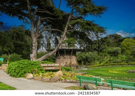 Queen Wilhelmina Garden with a round windmill, colorful flowers and lush green trees, grass and plants at Golden Gate Park in San Francisco California USA