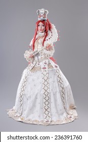 Queen wizard. Model dressed in renaissance style on gray background.