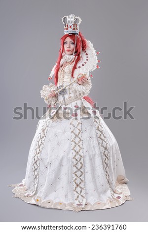 Queen wizard. Model dressed in renaissance style on gray background.