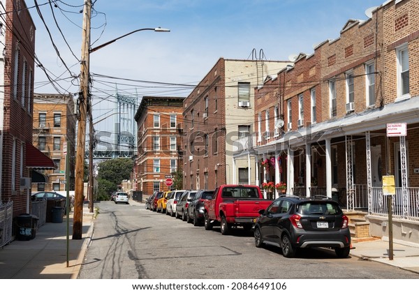 Queens, New York USA - August 7 2021: Astoria\
Queens Street with Old Homes and Residential Buildings with a view\
of the Triborough\
Bridge