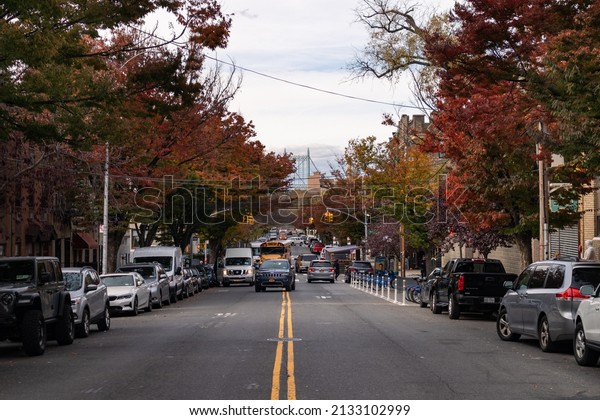 Queens, New York USA - November 4 2021: Astoria\
Queens Street with Colorful Trees during Autumn with a View of the\
Triborough Bridge