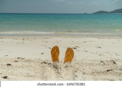 Queenstown, Australia - Feb 2020: Flip flops on Whitsundays beach, on white sand. Thongs in sandcastle. Aqua turquoise ocean background. Travel, holiday vacation, paradise, exotic. Whitsundays Islands