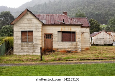 Queenstown, Australia-February 10, 2013.View of an old abandoned weatherboard home and shed in the rain in the mining township of Queenstown, Tasmania