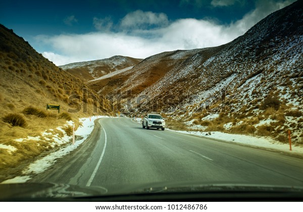 QUEENSTOWN NEW ZEALAND - SEP5,2015 : tourist car\
driving pass crown range road beautiful route from wanaka town to\
queenstown in south land new zealand\
