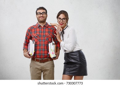 Queer couple of young educational workers stand together, being happy after visiting library, borrowed many books, going to read and develop themselves, enjoy reading process. Knowldege concept