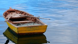 Quemchi, Isla De Chiloe, Chile - 14 De Febrero De 2020.bote De Remo Amarillo En Un Mar Tranquilo, Reflejos De Un Cielo Azulado.