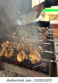 Quenching A Fire In A Smoky Grill. A Person Fight A Fire In A Grill