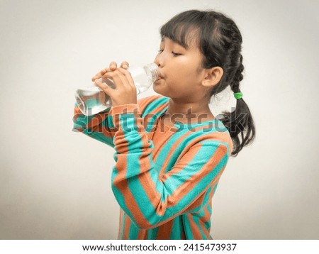 Quenching thirst: her face beams with satisfaction while sipping water from her trusty bottle.