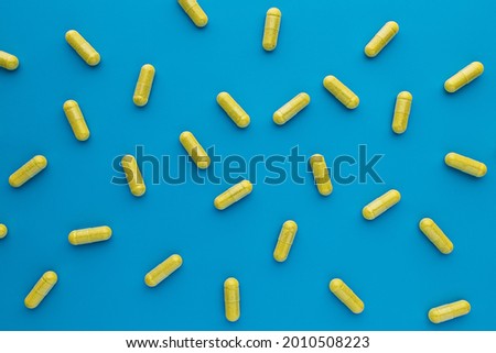 quercetin capsules on blue background. dietary supplement top view. mental wellbeing and personal health concept