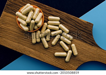 quercetin capsules on wooden board. mental wellbeing and personal health concept