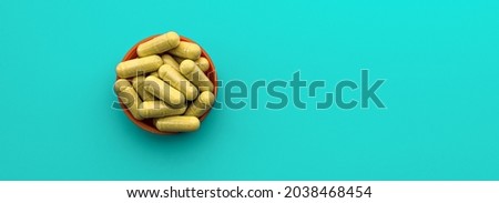 quercetin supplement capsules on turquoise background. dietary supplement top view banner. immune prevention care concept