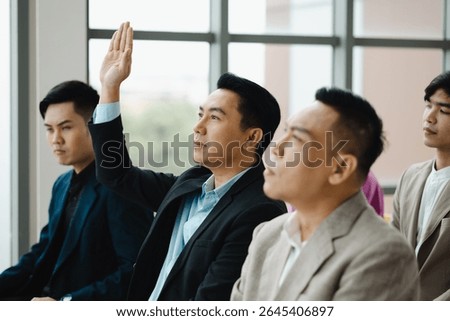 Question and answer audience or crowd : Active participation Asian man raise hands to ask questions attending seminar in conference meeting and training