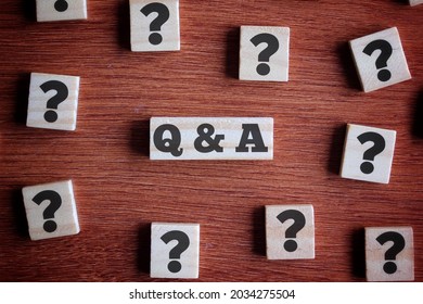 Question and answer concept. Top view of wooden cube with question mark symbol and text Q and A.