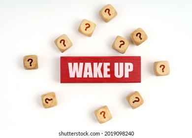 Question concept. On the table are cubes with questions and a red plaque with the inscription - Wake Up
