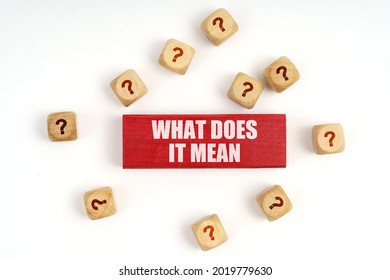 Question concept. On the table are cubes with questions and a red plaque with the inscription - What Does It Mean - Shutterstock ID 2019779630