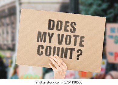 The question " Does my vote count? " on a banner in men's hand with blurred background. Presidential election. Voting. Politics. Government. Administration. Decision. Choice. Political battle