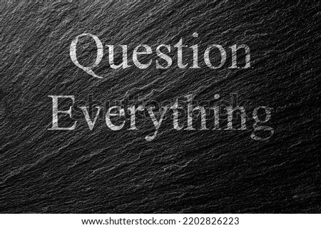 Question Everything Chalk text on black stone slab