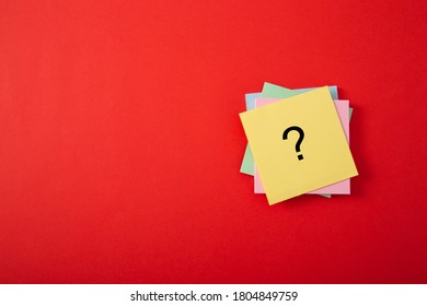 Question mark drawn on notepad. Over red background with copy space.