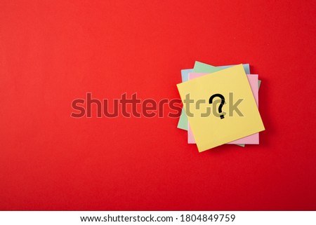 Question mark drawn on notepad. Over red background with copy space.