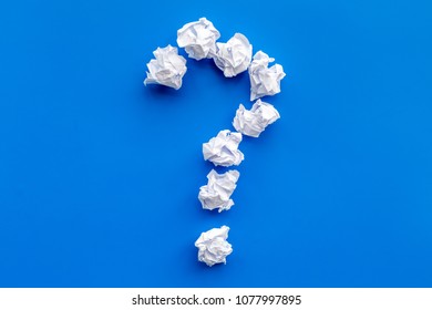 Question mark lined with crumpled paper on blue background top view copy space