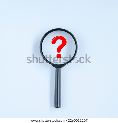 A question mark in a magnifying glass. Selective focus