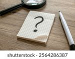 Question Mark on Graph Paper Notepad on Wooden Surface