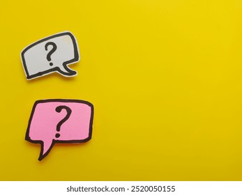 Question mark on speech bubble paper cut note isolated on yellow background. Frequently asked questions concept.