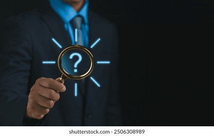question mark and problem analysis Concept,businessman hand hold magnifying glass with question mark show how to creatively analyze and find reasons that occur during the work process of business.