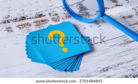 Question Mark Search: Stack of Blue Sticky Notes and Magnifying Glass on Wood