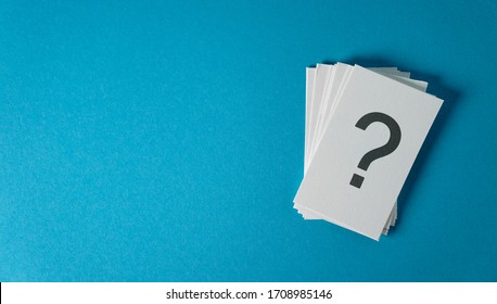 Question mark sign and symbol on white paper notes stack business and customer faqs concept on blue cyan background with copy space.