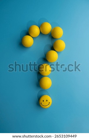 A question mark and smiling face composed of yellow balls with a blue background directly above
