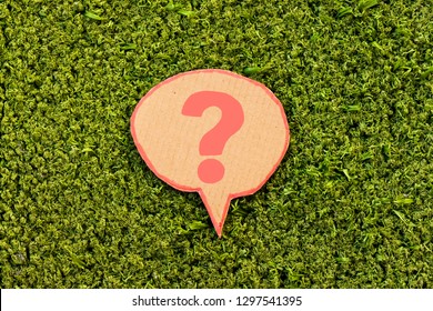 Question mark speech bubble above green grass