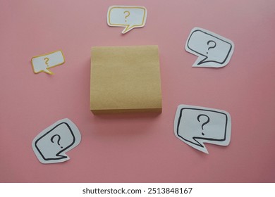 question mark in speech bubble on pink background. A piece of paper with a question mark, pinned to a pink surface, evoking curiosity. blank sticky notes.