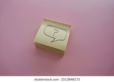 question mark in speech bubble on pink background. A piece of paper with a question mark, pinned to a pink surface, evoking curiosity. blank sticky notes.