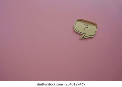 question mark in speech bubble on pink background. A piece of paper with a question mark, pinned to a pink surface, evoking curiosity. blank sticky notes.