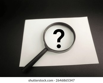 Question Mark Symbol Viewed Through Magnifying Glass on Paper, Concept of Inquiry, Uncertainty, Problem Solving, Research, Curiosity, Analysis, and Decision Making. 