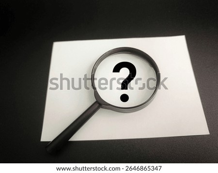 Question Mark Symbol Viewed Through Magnifying Glass on Paper, Concept of Inquiry, Uncertainty, Problem Solving, Research, Curiosity, Analysis, and Decision Making. 