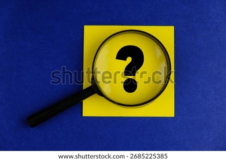 Question Mark Symbol Viewed Through Magnifying Glass on Paper, Concept of Inquiry, Uncertainty, Problem Solving, Research, Curiosity, Analysis, and Decision Making. 