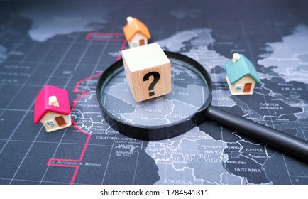 Question Mark Wooden Blocks With House On World Map. Concept Of Forecasting Future Housing Market Trends, Is It Time To Buy Or Sale House Due To Impact Of Economic Recession From Coronavirus Crisis