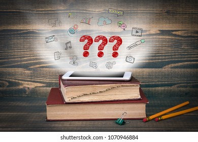 Question Marks. Concept cloud coming from screen of the phone, books on the desk