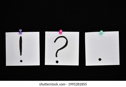question marks exclamation point and dot on bloy note on black background 