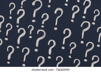 Question marks on a black background. Close up.
