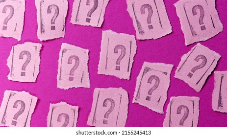 Question Marks Rubber Stamp Font Letters On Torn Paper Pink Background.