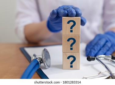 question marks text word inscription acronym on blocks in hands of doctor. medical questions and answers concept, gloves - Shutterstock ID 1801283314