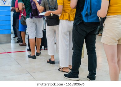 Queue Of Asian People Waiting At Boarding Gate At Airport. Close-up Composition