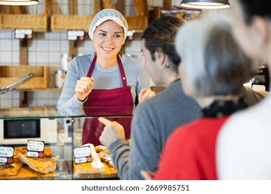 Queue of customers is lined up at counter of bakery. People place order at bakery, buy sweet pastries in cafeteria, girl worker serving people