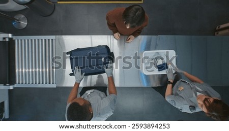 Queue of Diverse People, Passengers Putting Personal Items in Plastic Trays for X-ray Scanning. TSA Workers Controlling Screening Procedure. Airport Security Checkpoint for Boarding Flight. Top View.